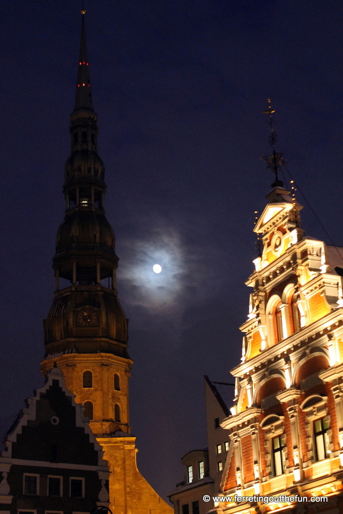 The moon shines between St Peter's Church and the House of the Blackheads in Riga, Latvia