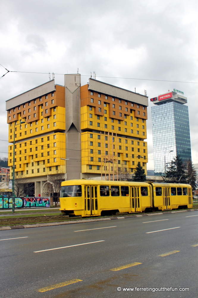 A yellow tram glides by the restored Holiday Inn on Sniper Alley in Sarajevo