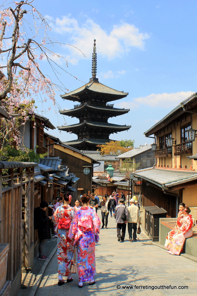 Kimono clad women walk down a street in Gion, the historic district of Kyoto, Japan.