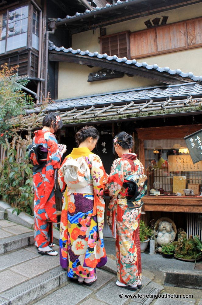 Tourists dressed in kimono near an old wooden shop in Kyoto, Japan 