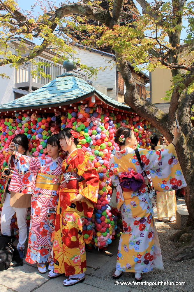 Kimono clad women pose for selfies in front of colorful Kongoji Temple in Kyoto