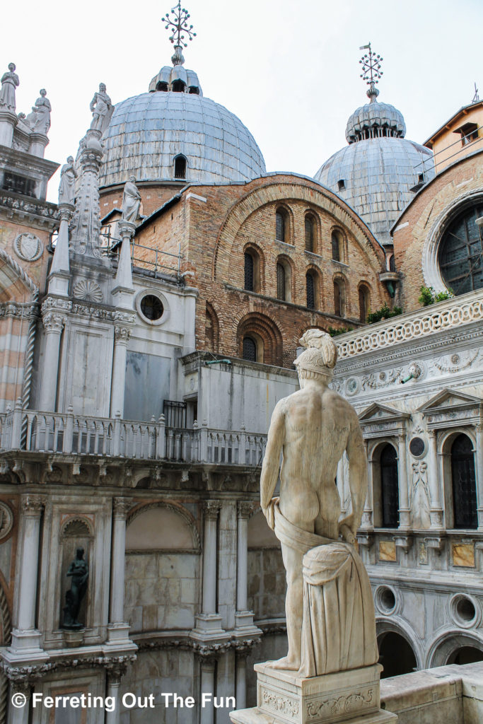 A sculpture of the Roman god Mars gazes upon St Mark's Basilica from the Doge's Palace in Venice, Italy
