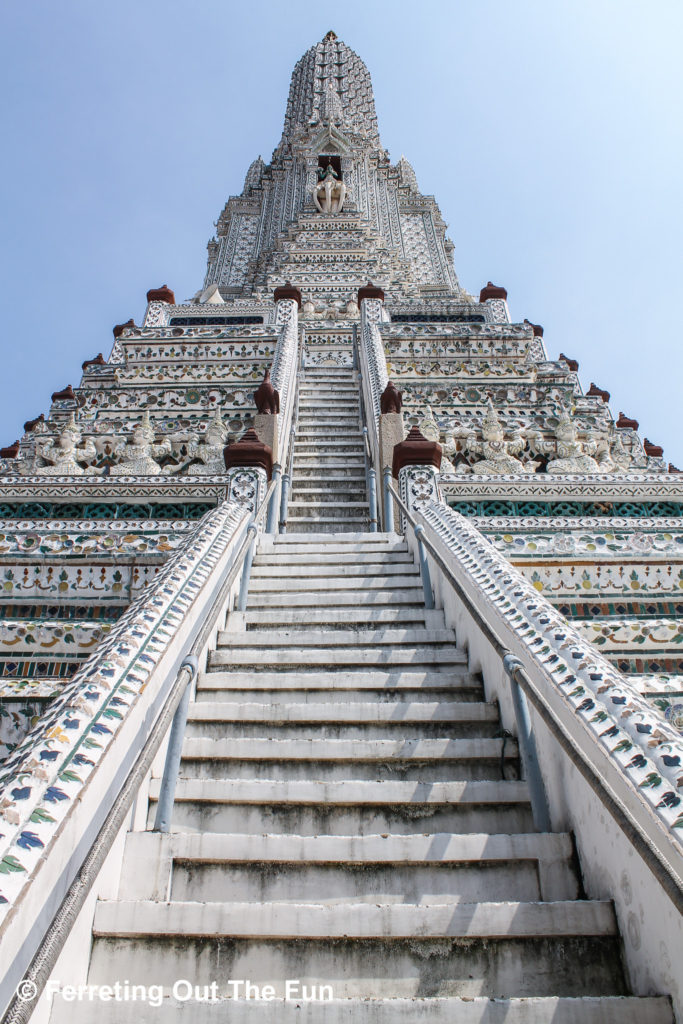 Climbing a steep staircase to the top of Wat Arun in Bangkok, Thailand
