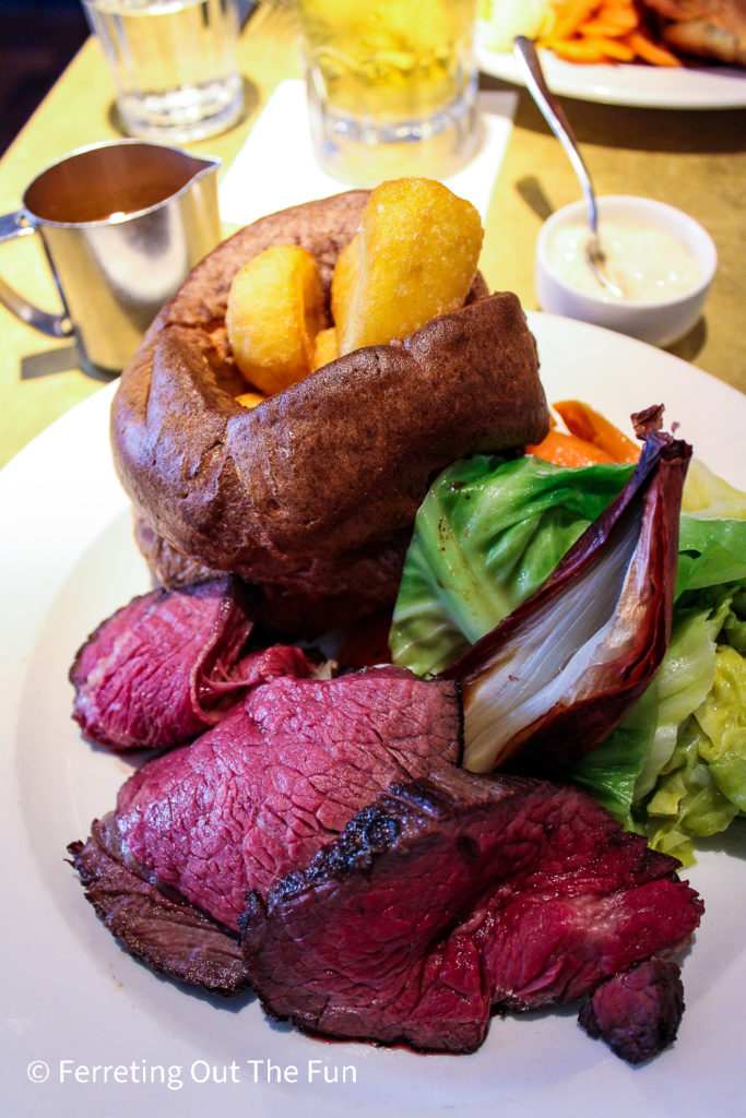 Traditional Sunday Roast, a British classic. Roast beef with Yorkshire pudding, crisp potatoes, and vegetables.