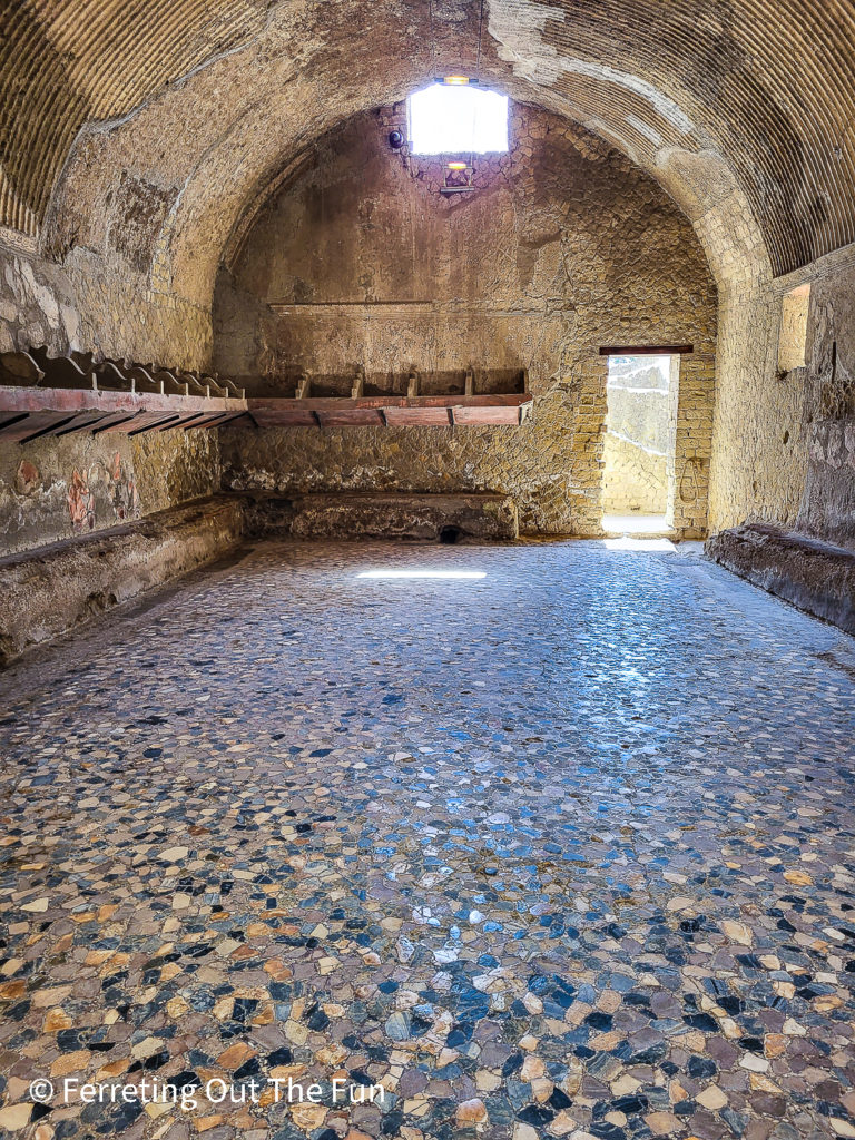 Roman bath complex with benches and storage shelves under a vaulted ceiling