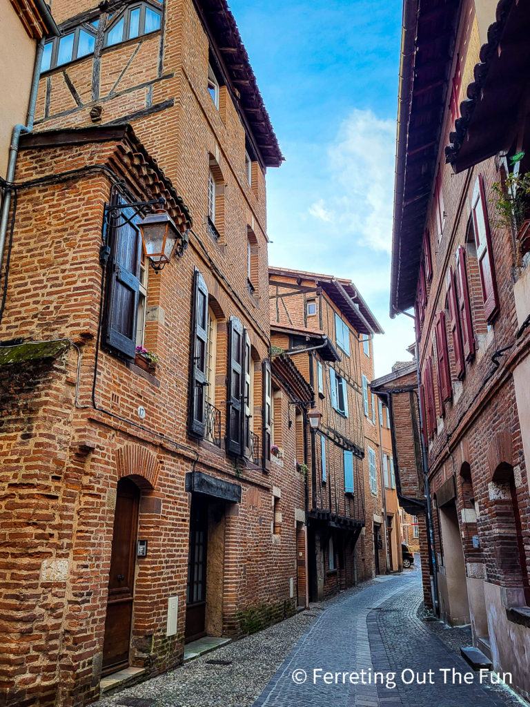 An alleyway lined with medieval brick buildings in Albi, France