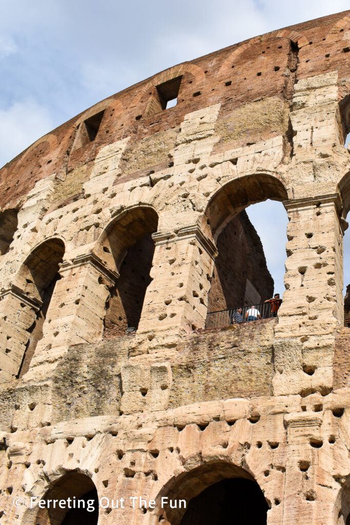 The Colosseum facade shows where medieval pillagers dug out the metal support brackets to use for tools and weapons. Rome, Italy.